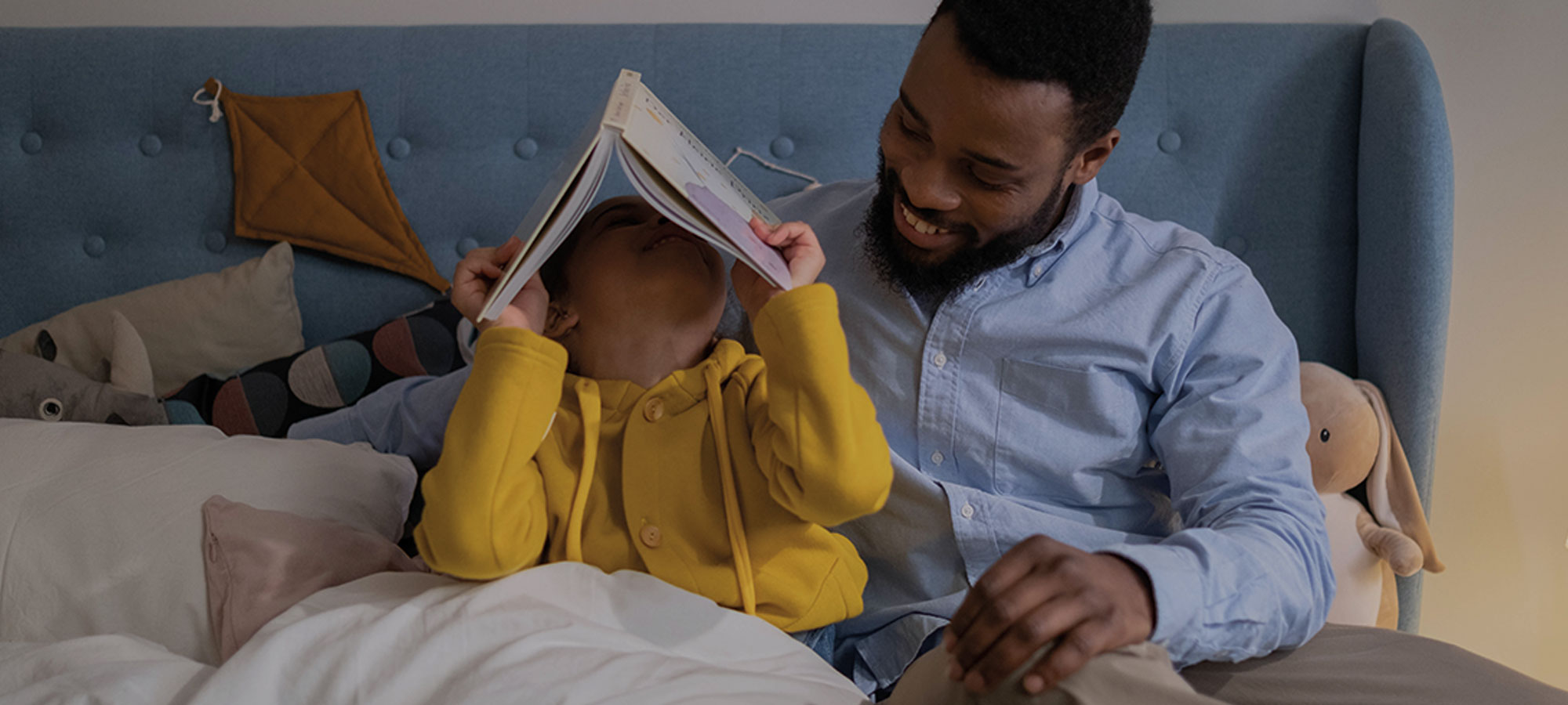 Father reading his autistic child a story in bed.