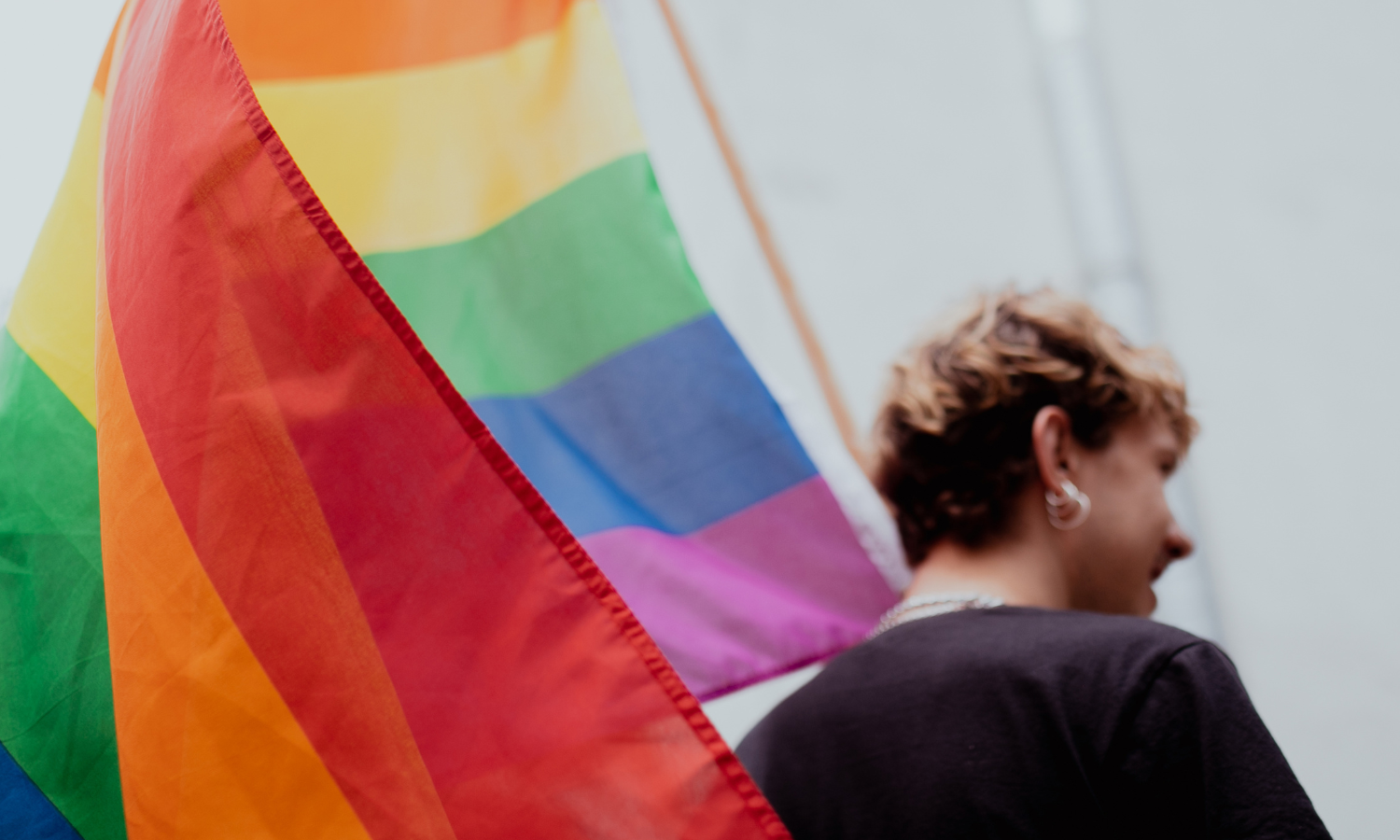 LGBTQ+ community member holding the flag