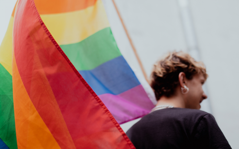 LGBTQ+ community member holding the flag