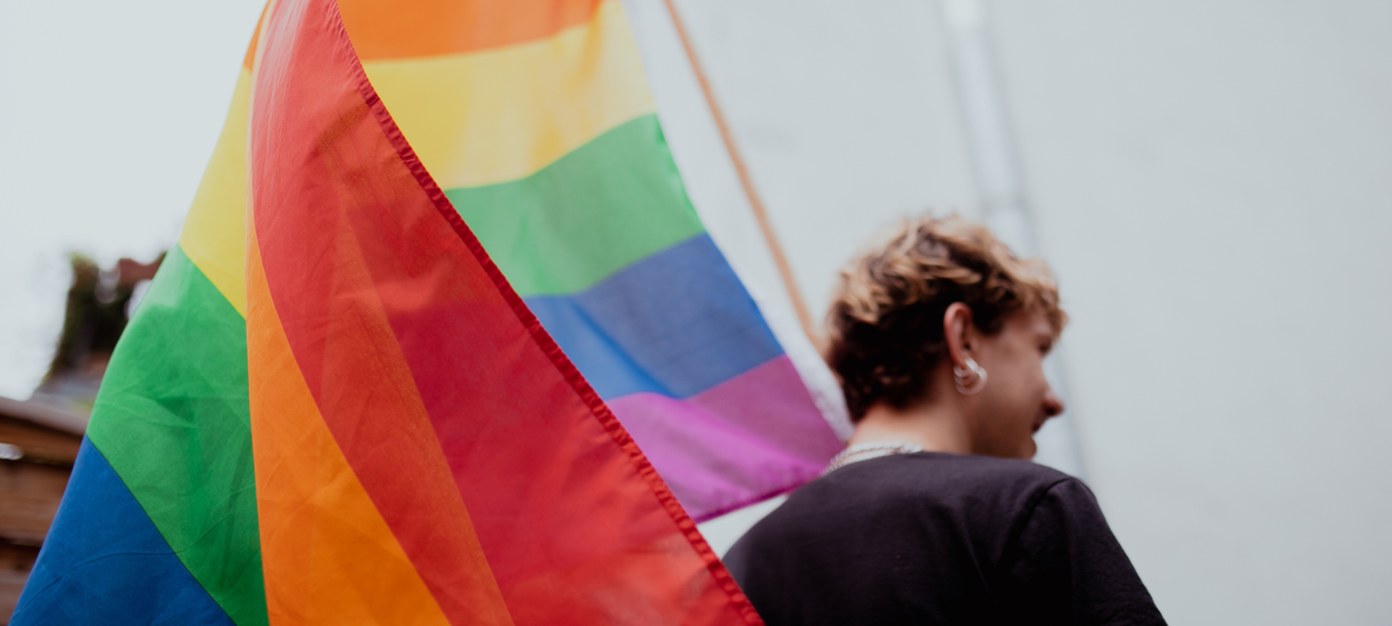 LGBTQ+ community member holding the flag